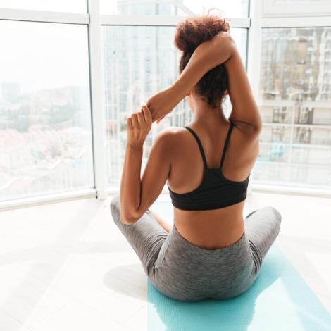 Back view of woman stretching hands before training